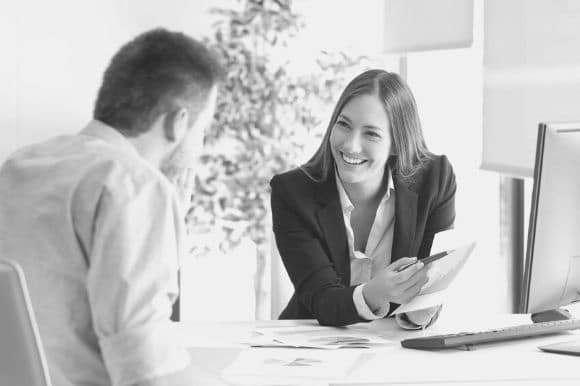 Benefits analyst talking with client in office