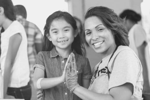 Public health nurse with child patient at community event