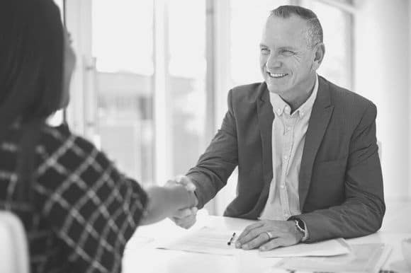 A recruiter meets with a potential candidate. These tips will help you keep your talent pipeline warm during a hiring freeze.