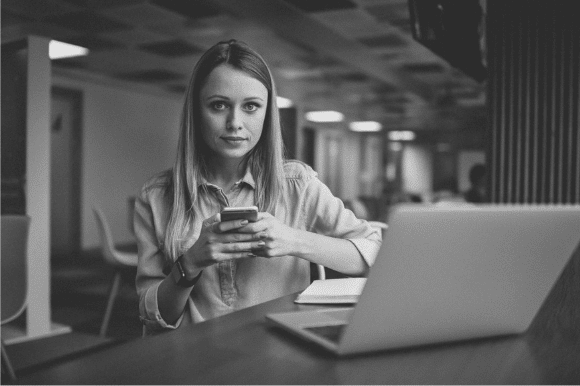 Woman on her cellphone at her computer