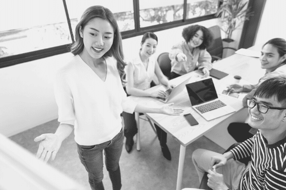 Young woman leading her colleagues in an upskilling session at the office.
